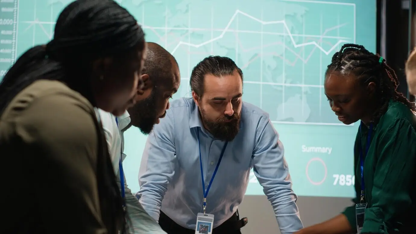 Des collègues de divers horizons assistent à une réunion d’affaires après les heures de bureau pour l’analyse de fichiers.